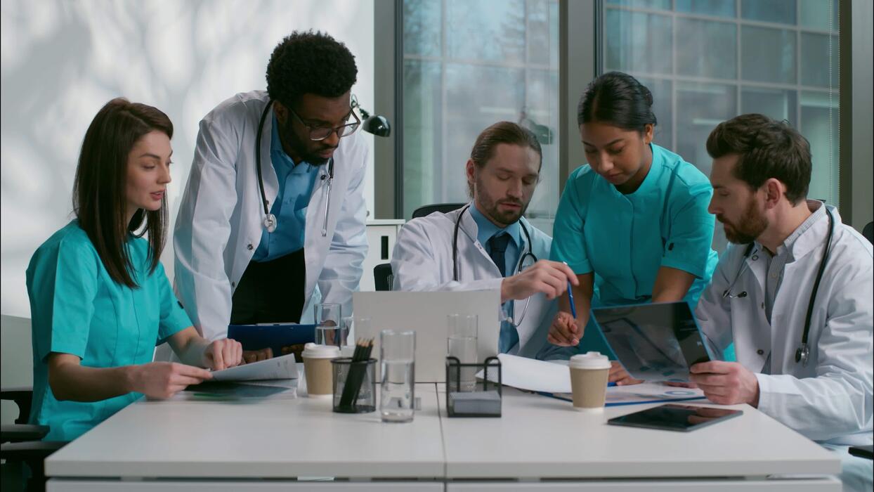 Equipo médico colaborando con tecnología digital en consultorio